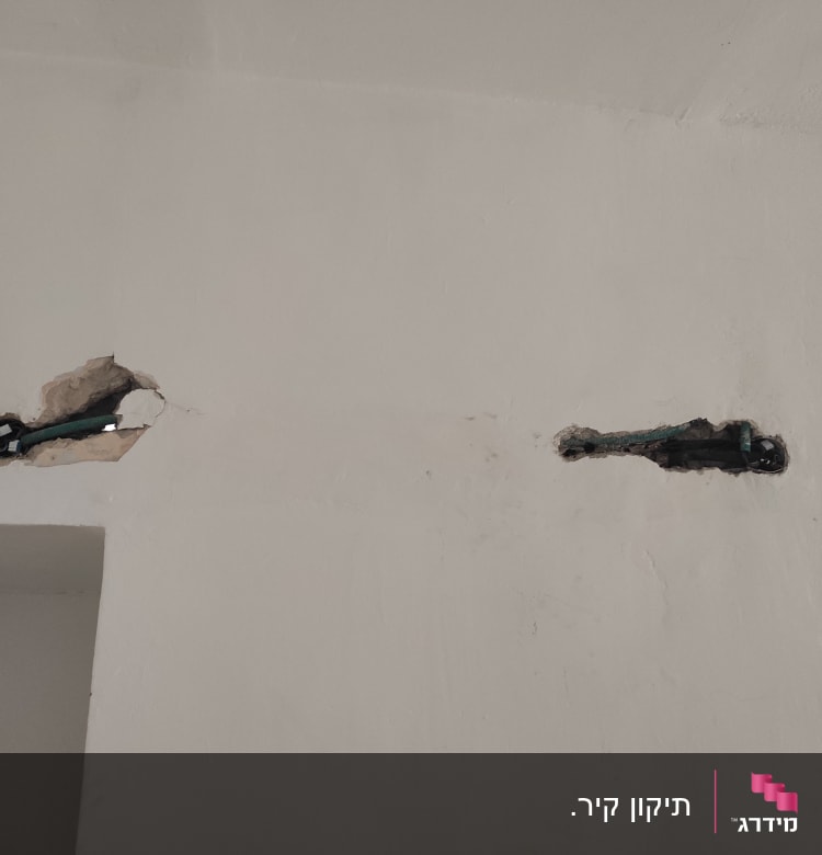 שני חורים בקיר עם צינורות חשמל חשופים